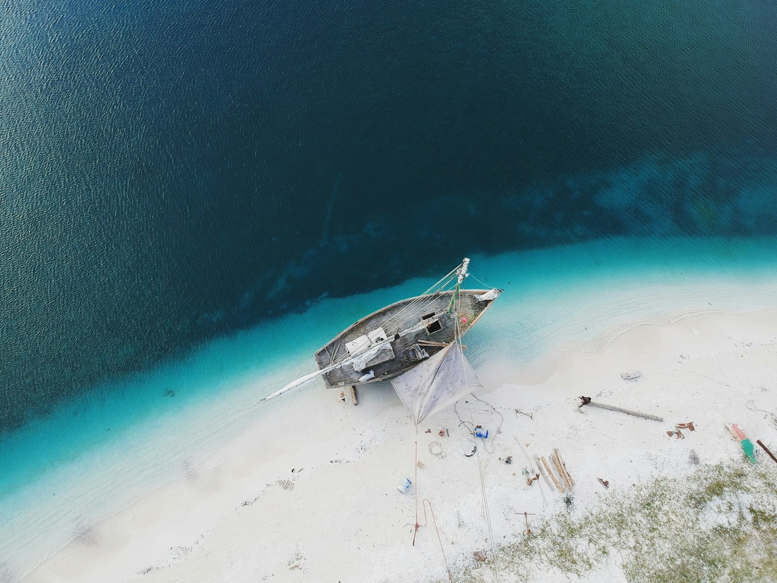 A wooden sailboat on turquoise water
